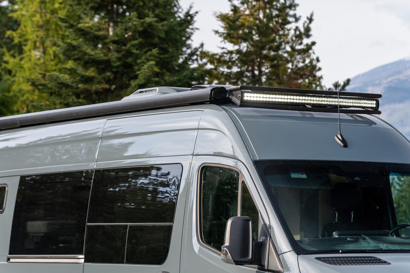 The exterior of a van in a field with a 50 inch rooftop light bar