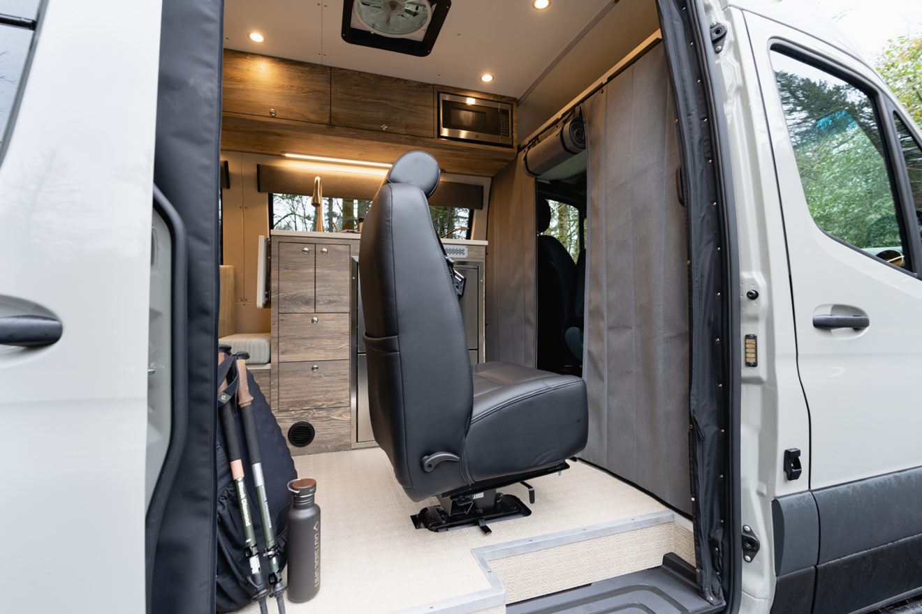Passenger-side slider door open showing a removable captain's chair and soft garage wall