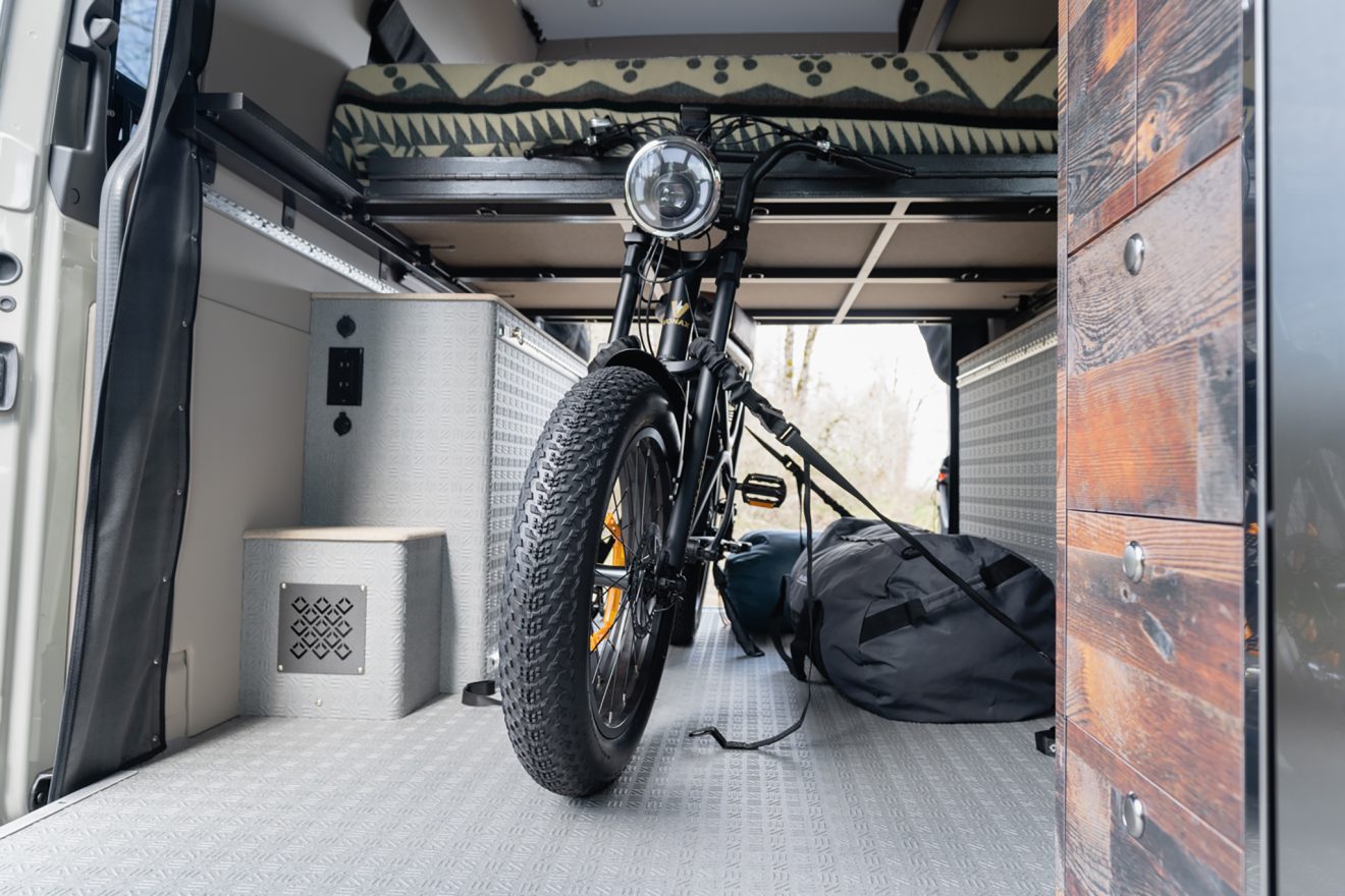 Interior of a van with an e-bike strapped down in the middle
