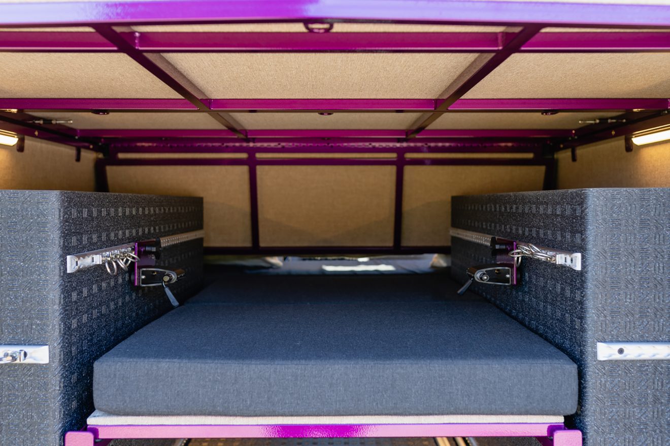 Garage interior looking toward the front of the van with purple powdercoating metal panels