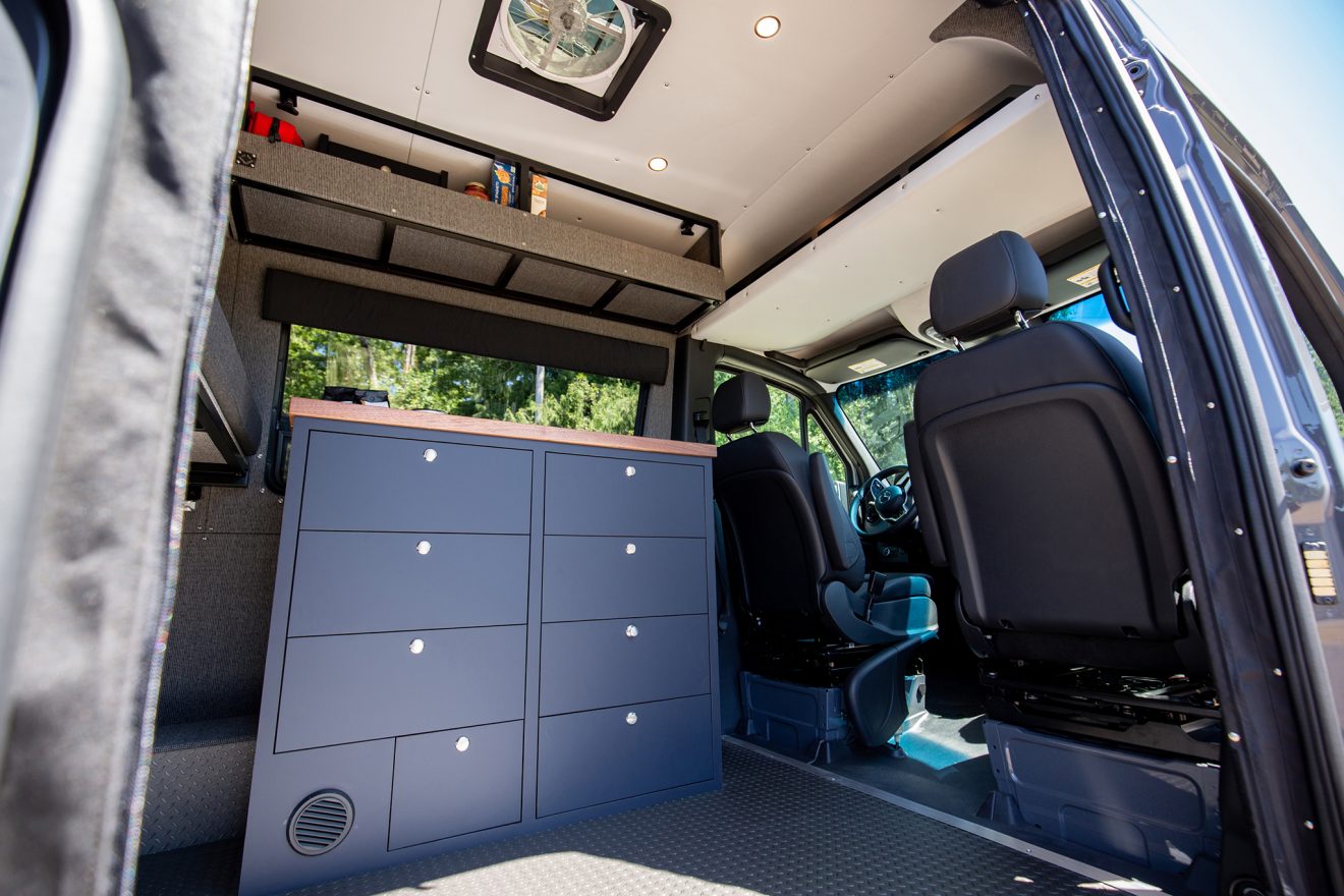 Detail image of blue six drawer cabinetry inside custom off road 144 sprinter van