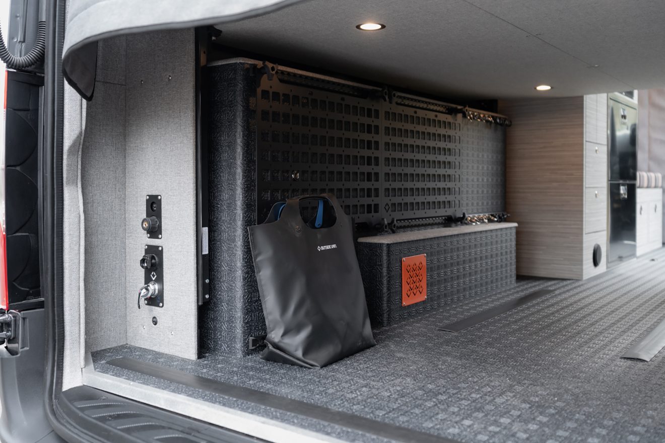 Rear garage interior with freshwater exterior shower and cargo molle panels