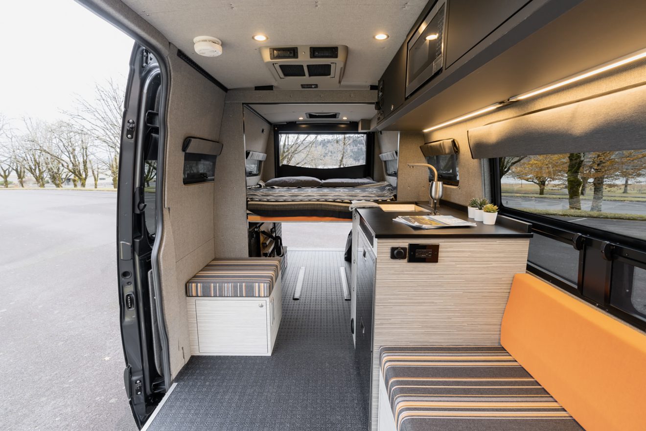 Interior cabin with electronic bed lowered, custom orange and grey upholstery seating