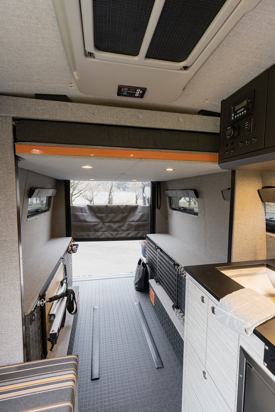 Interior cabin with electronic bed raised, custom orange and grey upholstery seating