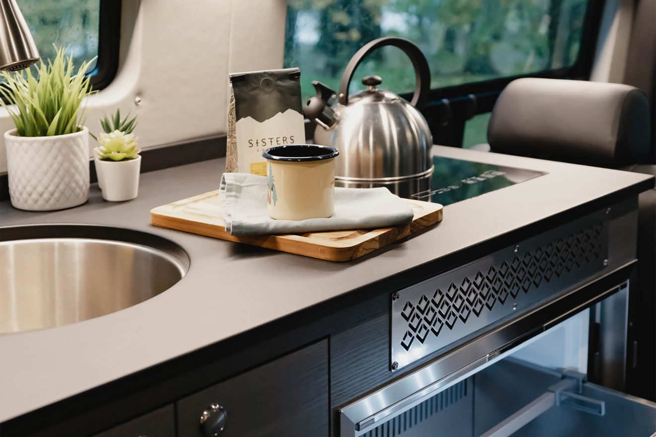 Black countertop with storage drawers, sink, and induction burner
