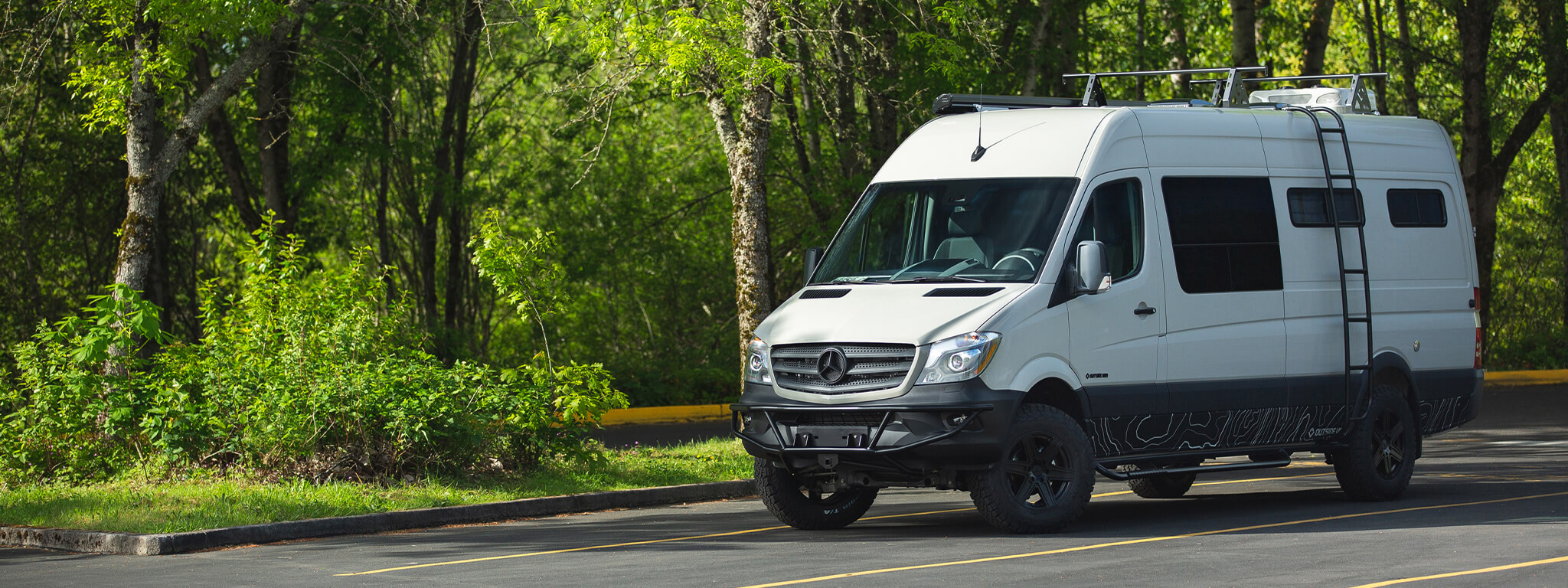 Outside Van's Bear's Den is a 170" custom van for family camping. Seating and sleeping for 4 with galley exterior shower